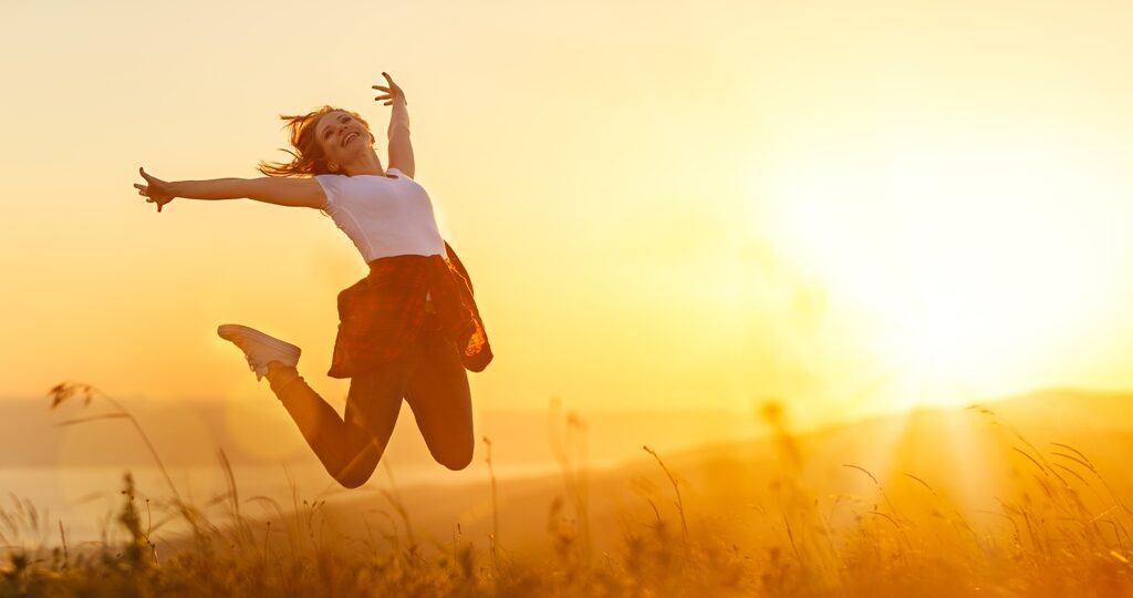 Happy woman   jump,  rejoices, laughs  on sunset in nature