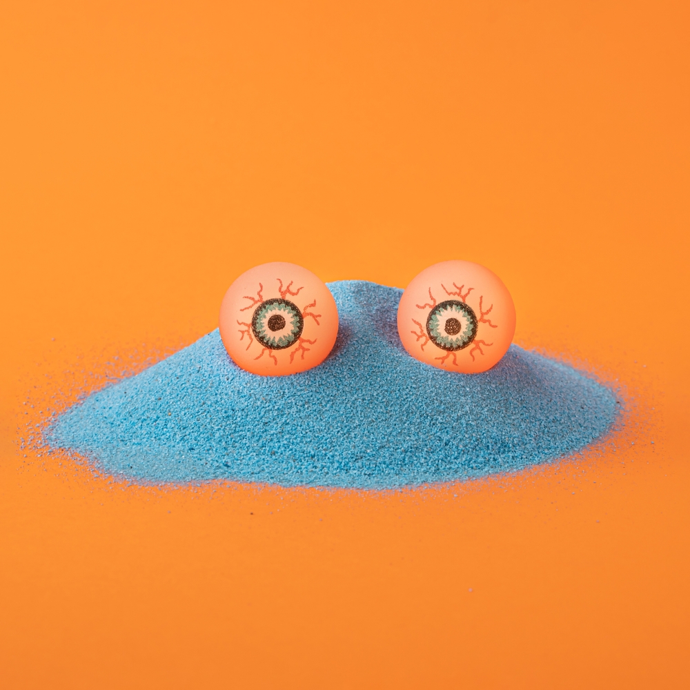 Creative,Concept,Of,Blue,Sand,Creature,With,Eyes,On,Orange